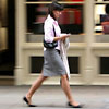 woman texting on a mobile phone whilst walking along the pavement